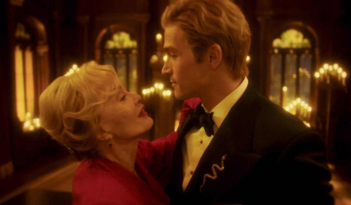 Due figure in una sala illuminata da luci dorate in American Horror Story 13x09