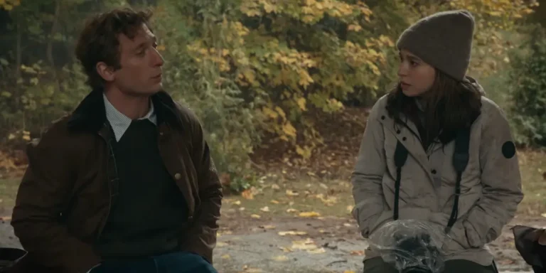 Mikey Madison e Jeremy Allen White conversano all'aperto in un bosco autunnale in una scena del film The Social: Il Prezzo Della Verità.